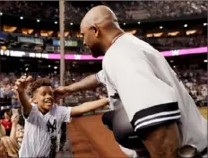  ?? Associated Press ?? Yankees pitcher CC Sabathia receives a hug from son Carter after notching strikeout No. 3,000 Tuesday night in Phoenix.