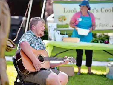  ?? TIM MARTIN/THE DAY ?? Jesse Edwards, of Mystic, performs an acoustic set during the New London Field of Greens Farmers Market in New London’s Williams Park on Friday afternoon.