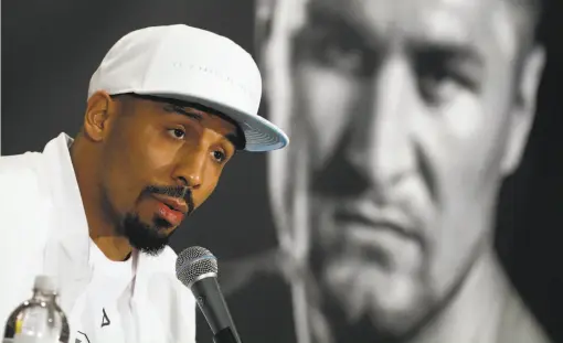  ?? John Locher / Associated Press ?? Sergey Kovalev’s visage looms large behind Andre Ward as the Oakland fighter speaks during a pre-fight news conference in Las Vegas.