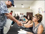  ?? Arkansas Democrat-Gazette/MITCHELL PE MASILUN ?? Fernando Fernandez (left) of Little Rock thanks Gloria Bastidas of the Arkansas Department of Education for helping him with paperwork during the opening of the city’s multicultu­ral liaison office on Saturday.