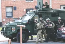  ?? STAFF PHOTO BY DOUG STRICKLAND ?? The Chattanoog­a SWAT Team moves to breach an apartment Tuesday at the end of a standoff at East Lake Courts. A search of the apartment showed it was empty.