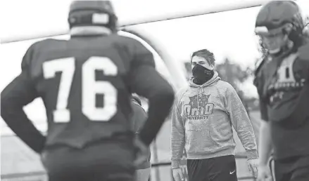  ?? FRED SQUILLANTE/COLUMBUS DISPATCH ?? Hartley High School senior offensive lineman Jake Skelly, center, who was sidelined by leukemia, watches his teammates practice.