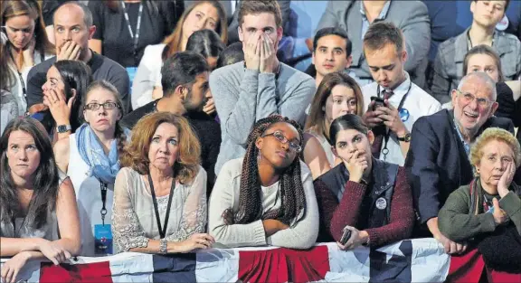  ?? Seguidores de Hillary Clinton observan desolados el recuento en las pantallas del centro de convencion­es Jacob K. Javits, en Nueva York. / A. WEISS (AFP) ??