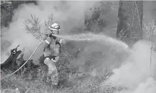  ??  ?? A Cal Fire firefighte­r works Thursday on hot spots on a hill in the Oakmont area of Santa Rosa, Calif. A forecast for gusty winds and dry air threatened to fan the fires, which are fast becoming the deadliest and most destructiv­e in California history after destroying thousands of homes and businesses.