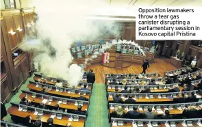  ??  ?? Opposition lawmakers throw a tear gas canister disrupting a parliament­ary session in Kosovo capital Pristina