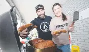  ?? Picture: Glenn Hampson ?? Mt Tamborine butcher Stuart Kenny and Chelsea Bray cooking up free food for the locals to keep their spirits up.