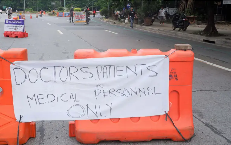  ?? (PNA photo by Robert Oswald P. Alfiler) ?? FRONT-LINERS ONLY. Authoritie­s monitor those entering East Avenue from the Elliptical Road to BIR road in Quezon City due to several major hospitals in the area on Thursday (May 21, 2020). Only doctors, medical personnel, and patients are given the priority to access the area.