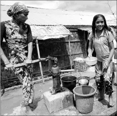 ??  ?? Muslim girls carrying water in Da Paing IDP camp near Sittwe town.
