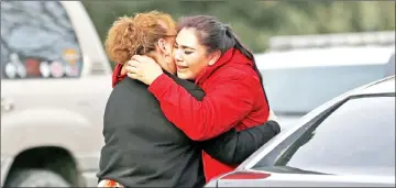  ??  ?? Vanessa Flores (right) embraces another woman after she leaves the locked down Veterans Home of California.