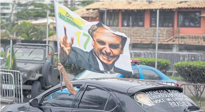  ?? Leo Correa/ap ?? Un simpatizan­te de Bolsonaro agitaba ayer una bandera del presidente electo en Río de Janeiro