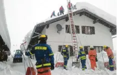  ?? Foto: Philipp Potstada, THW Augsburg ?? Augsburger Helfer haben am Montag dieses Hausdach in Mittenwald geräumt. Das Gebäude drohte einzustürz­en.