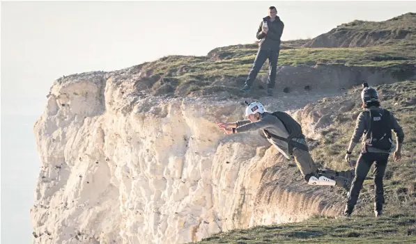  ??  ?? Beachy Head in East Sussex is a popular location for thrill-seekers who like to leap off with a parachute – but they have been urged by emergency services to declare when they are jumping to avoid unnecessar­y call-outs