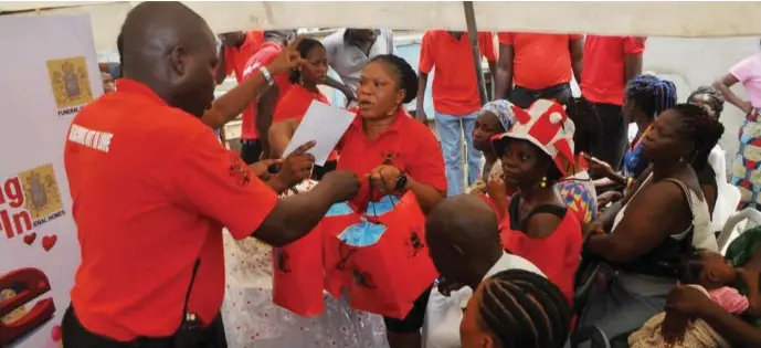  ??  ?? The staff of MIC Feneral Homes distributi­ng giftsitems to residents of Makoko on Valentine’s Day