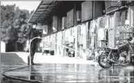  ?? LONG YUYANG / CHINA NEWS SERVICE ?? A worker disinfects stalls and facilities at a live poultry wholesale market in Guangzhou on Monday. After reports of four people infected with H7N9 bird flu virus last week, Guangdong province ordered a one-day closure of live poultry markets for...