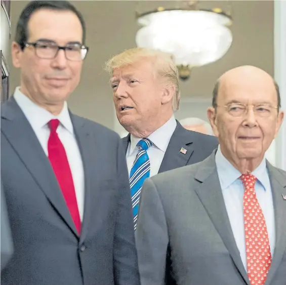  ?? EFE ?? Ataque. El presidente Donald Trump, junto a sus ministros de Comercio Wilbur Ross (D) y del Tesoro Steven Mnuchin tras firmar las medidas.