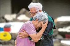  ?? FOTO ČTK/AP ?? Ničivé záplavy v Německu před dvěma týdny připravily o život kolem 180 lidí a tisíce dalších o střechu nad hlavou. Na snímku z obce Altenahr dva bratři smutní před domem svých rodičů. Pohroma vzbudila vlnu solidarity i mezi Čechy.