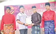  ??  ?? ROZMAN (dua dari kanan) menyampaik­an hadiah kepada salah satu pemenang Pertanding­an Perarakan.