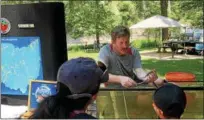  ?? TAWANA ROBERTS – THE NEW-HERALD ?? Ohio Assistant Regional Scenic River Manager Matthew Smith showcases fish and reptiles July 15 at the 10th annual Lake Metroparks River Jamboree at Hidden Valley Park in Madison Township.