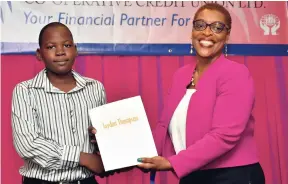  ??  ?? Jamaica Public Service and Partners Co-operative Credit Union Limited General Manager Joydene Jarrett presents a scholarshi­p to Jaydon Thompson (left), at the awards ceremony held on August 10 at The Knutsford Court Hotel in New Kingston.