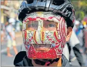  ?? AFP ?? A protesters wearing an improvised protective gear looks on during a demonstrat­ion against the coup in Yangon.