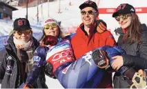  ?? ALESSANDRO TROVATI/ASSOCIATED PRESS ?? Mikaela Shiffrin gets a ride from her brother Taylor, flanked by Taylor’s wife, Kristi, right, and by Shiffrin’s mother, Eileen, after the skiing icon’s record-setting 87th World Cup victory in Sweden.