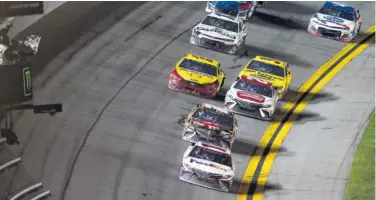  ?? AP PHOTO/DAVID GRAHAM) ?? Denny Hamlin takes the checkered flag to win the Daytona 500 on Sunday at Daytona Internatio­nal Speedway.