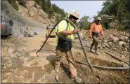  ?? JEREMY PAPASSO -FILE PHOTO ?? Fidel Guerrero, left, and Mike James, with HTM Constructi­on, work to pour concrete for shoring to widen the road while working on flood repairs on James Canyon Drive near Jamestown in 2017.