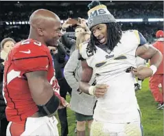  ?? Matt Dunham Associated Press ?? TODD GURLEY of the Rams, right, prepares to swap jerseys with Arizona Cardinals running back Adrian Peterson last Sunday.