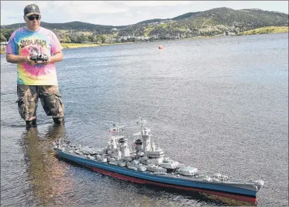  ?? JOE GIBBONS/THE TELEGRAM ?? Retired Canadian Forces member and military model boat enthusiast Kurt Stokes uses a remote control to sail the boat in the waters at Quidi Vid Lake last week with a replica model of the American Navy military ship USS Montana, a prototype which was to...