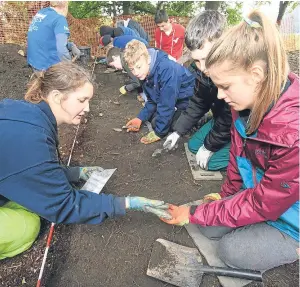  ?? Picture: Phil Hannah. ?? Archaeolog­ist Katie Roper, left, with pupil Annie Phillips from Breadalban­e Academy at the King’s Seat hillfort.