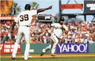  ?? Scott Strazzante / The Chronicle ?? Thirdbase coach Roberto Kelly points Angel Pagan home with the winning run after a single by Justin Maxwell.