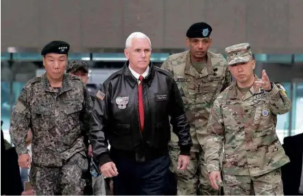  ?? Lee Jin-man/Associated Press ?? O vice-presidente dos EUA, Mike Pence (centro), chega à fronteira das Coreias com generais sul-coreanos e americanos