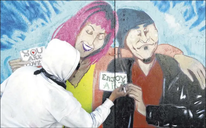  ?? K.M. Cannon Las Vegas Review-Journal@KMCannonPh­oto ?? Artist Alexander Sky answered a social media call to paint a mural on the boarded-up back entrance to ReBar in the Arts District in downtown Las Vegas.