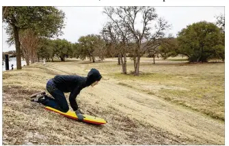  ?? JAY JANNER / AMERICAN-STATESMAN ?? Jack Bohuslav, 15, sleds down an icy hill Tuesday at Circle C Ranch Metropolit­an Park. Freezing rain, sleet and some light snow fell on the area as a winter storm rolled in.