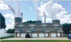  ?? AP PHOTO/JOHN RABY ?? American Electric Power’s John Amos coal-fired plant in Winfield, W.Va, is seen from an apartment complex in the town of Poca across the Kanawha River in 2018.