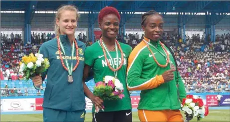  ??  ?? Gold medalist of the women’s 100m hurdles, Nigeria’s Oluwatobil­oba Amusan (centre); Silver medalist, Steenkamp Rikennete of South Africa; and Okou Rosvitha of Côte d Ivoire on the podium shortly after event in Asaba…yesterday