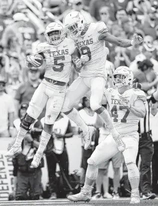  ?? Vernon Bryant / Dallas Morning News ?? UT’s Tre Watson, left, and Collin Johnson are jumping for joy after Watson scored on a 28-yard reception in the second quarter at the Cotton Bowl