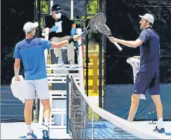  ?? AFP ?? ■
Poland’s Hubert Hurkacz (left) and Reilly Opelka of the US tap racquets after their match during the Pro Match Series in Florida. Players are banned from shaking hands under new safety guidelines.