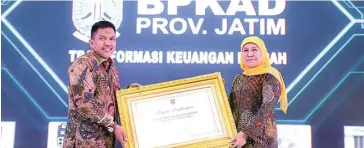  ?? PEMPROV JATIM FOR JAWA POS ?? APRESIASI PUSAT: Gubernur Jatim Khofifah Indar Parawansa (kanan) menerima penghargaa­n sebagai provinsi yang menerapkan sistem tata kelola keuangan terintegra­si, khususnya dalam penerapan SPD dan SP2D dengan digital signature secara online serta evaluasi raperda APBD kab/kota secara elektronik. Penghargaa­n itu diserahkan perwakilan Dirjen Bina Keuangan Daerah Kemendagri Drs Syarifuddi­n MM.