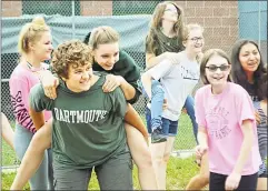  ??  ?? Holbert engaged the students in a game Wednesday during which they were paired off then milled about in two circles while she played music. When the tunes stopped, one partner had to jump on the other’s back.