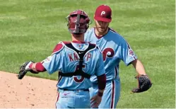  ?? BILL STREICHER/USA TODAY SPORTS ?? Phillies pitcher Zack Wheeler and catcher Andrew Knapp (5) celebrate after a 2-0 victory against the Brewers on Thursday.