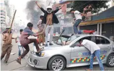  ?? — Reuters ?? Bangladesh Nationalis­t Party activists vandalise a police vehicle during clashes in Dhaka on Wednesday.