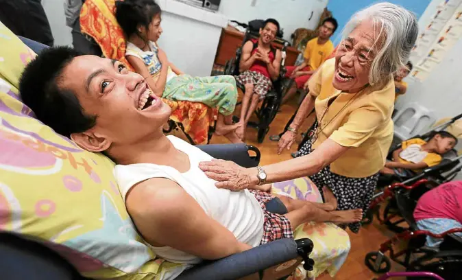  ??  ?? FUN TIME At Handicap Center Lourdes inside Caritas Pandacan, Celeste Sanchez uses music to interact with PWDs, teaching them to breathe properly through the diaphragm (above), or forming an impromptu orchestra using small instrument­s that she herself...