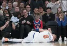  ?? MARY ALTAFFER — THE ASSOCIATED PRESS ?? The Knicks’ Kristaps Porzingis lies on the ground after being injured against Milwaukee Tuesday at Madison Square Garden in New York.