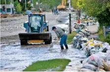  ?? AP PHOTO/MATTHEW BROWN ?? Residents of Red Lodge, Mont., clear mud, water and debris from the small city’s main street on Tuesday after flood waters coursed through a residentia­l area with hundreds of homes.