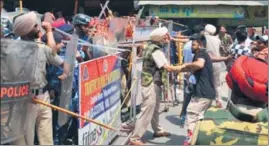  ?? PARDEEP PANDIT/HT ?? ■ A policeman trying to stop a Dalit activist from crossing a barricade at a market in Phagwara on Sunday.