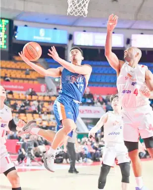  ?? PHOTOGRAPH COURTESY OF EASL ?? ANJO Caram of Meralco slices through the heart of the Seoul SK Knights defense during their East Asia Super League game in Seoul. The Bolts lost, 62-72.