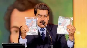  ??  ?? President Nicolas Maduro shows what Venezuelan authoritie­s claim are identifica­tion documents of former US special forces and US citizens Airan Berry, right, and Luke Denman, left.