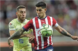  ?? ?? VÍCTOR GUZMÁN (der.) de Chivas disputa un balón con Sebastián Cáceres de América