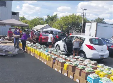  ?? BOB KEELER - MEDIANEWS GROUP ?? Volunteers load free food into cars at the Aug. 20 contactles­s drive-through food distributi­on by Garden of Health in Lansdale.